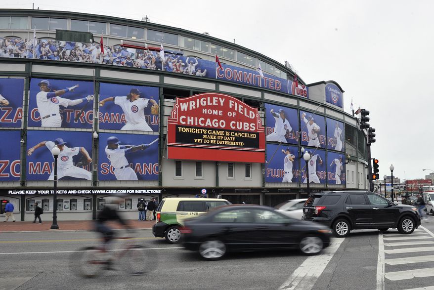 Traffic drives past Wrigley Field after the baseball game between the Milwaukee Brewers and Chicago Cubs was postponed due to inclement weather on Wednesday, April 10, 2013, in Chicago. (AP Photo/Jim Prisching)