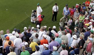 Bubba Watson hits out of the crowd on the fourth fairway during the first round of the Masters golf tournament Thursday, April 11, 2013, in Augusta, Ga. (AP Photo/Charlie Riedel)