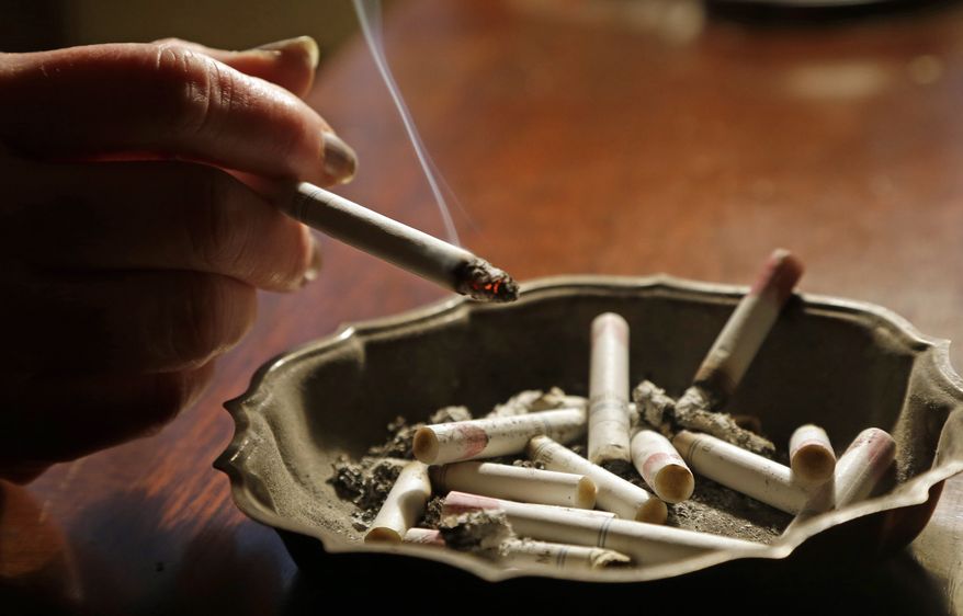 **FILE** A woman smokes a cigarette at her home in Alabama on March 2, 2013. (Associated Press)