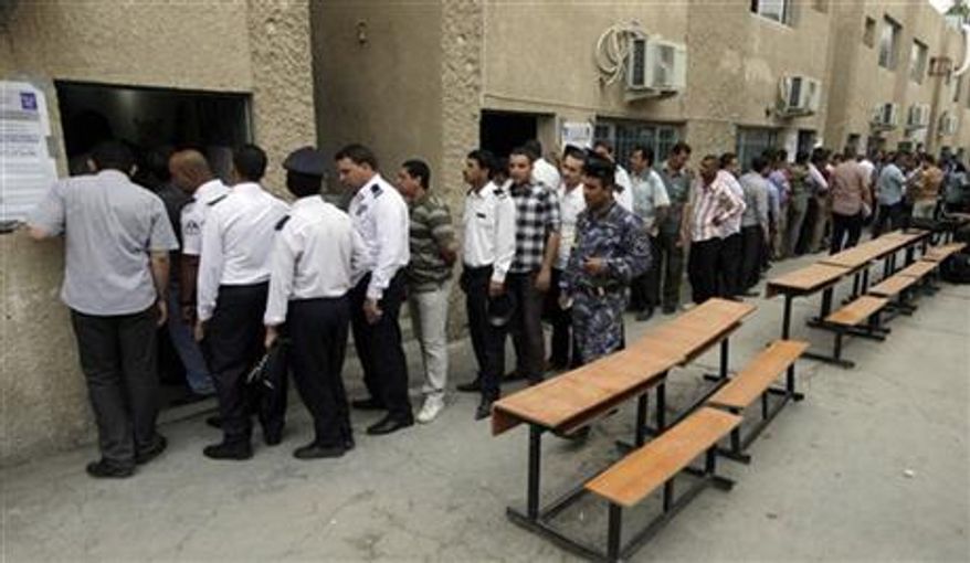 Iraqi security forces queue to vote at a polling center during the early voting in Baghdad, Iraq, Saturday, April 13, 2013. Voters head to the polls next week for the first time since the U.S. military withdrawal. (AP Photo/ Khalid Mohammed)