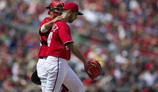 Washington Nationals catcher Kurt Suzuki, left, talks with pitcher Gio Gonzalez during the first inning of a baseball game at Nationals Park on Sunday, April 14, 2013, in Washington. (AP Photo/Evan Vucci)