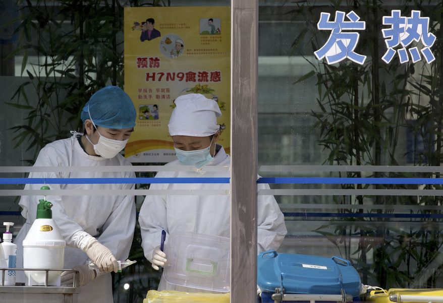Nurses collect patients' blood samples at a specialized fever clinic inside the Ditan Hospital, where a Chinese girl is being treated for the H7N9 strain of bird flu, in Beijing on Sunday, April 14, 2013. (AP Photo/Andy Wong)