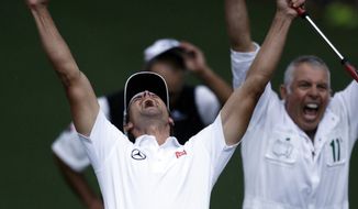 Adam Scott, of Australia, celebrates with caddie Steve Williams after making a birdie putt on the second playoff hole to win the Masters golf tournament Sunday, April 14, 2013, in Augusta, Ga. (AP Photo/Darron Cummings)