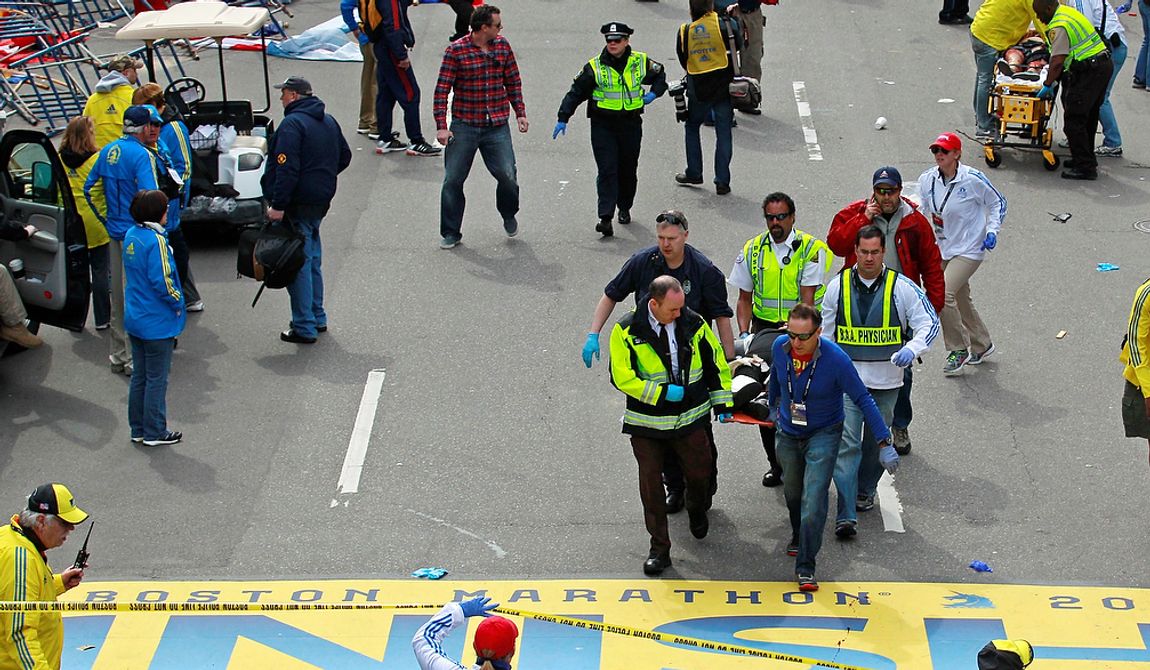Medical workers wheel the injured across the finish line during the 2013 Boston Marathon following an explosion in Boston, Monday, April 15, 2013. Two explosions shattered the euphoria of the Boston Marathon finish line on Monday, sending authorities out on the course to carry off the injured while the stragglers were rerouted away from the smoking site of the blasts. (AP Photo/Charles Krupa)