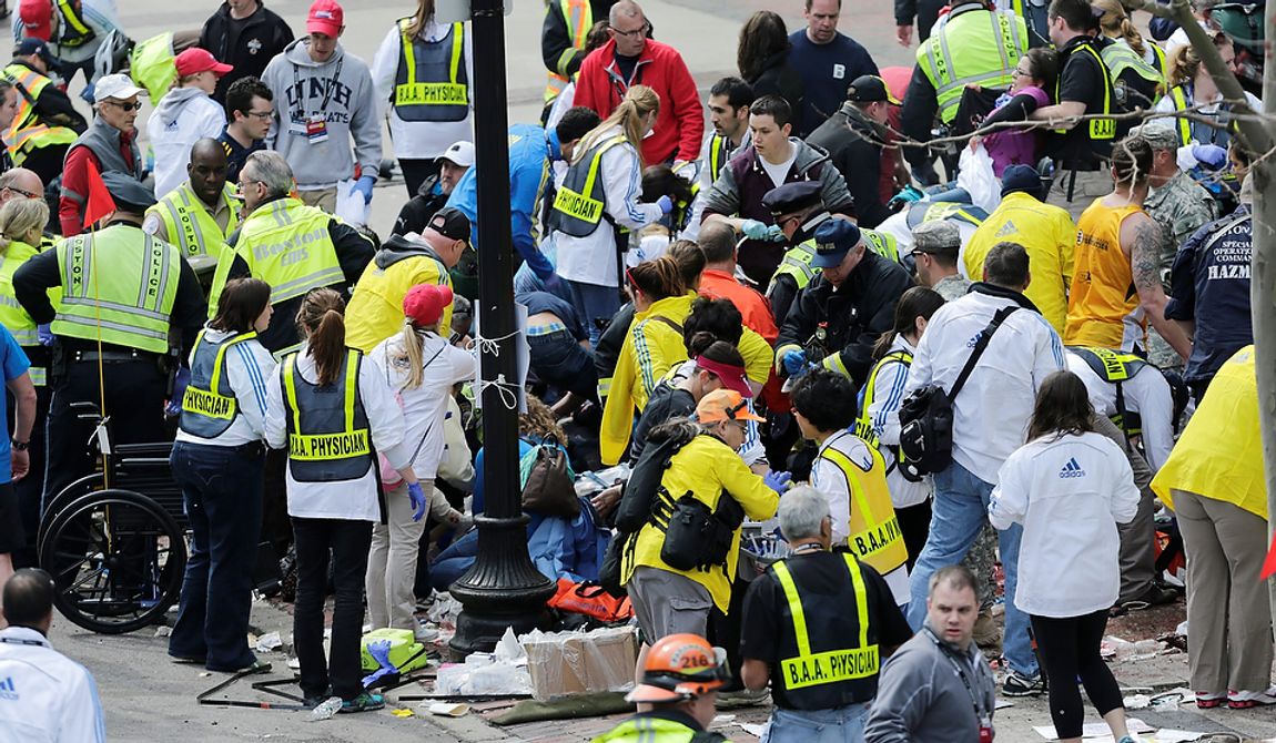 Medical workers aid injured people at the finish line of the 2013 Boston Marathon following an explosion in Boston, Monday, April 15, 2013. Two explosions shattered the euphoria of the Boston Marathon finish line on Monday, sending authorities out on the course to carry off the injured while the stragglers were rerouted away from the smoking site of the blasts. (AP Photo/Charles Krupa)