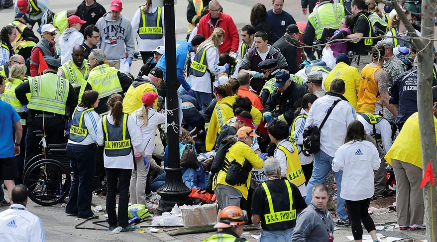Medical workers aid injured people at the finish line of the 2013 Boston Marathon following an explosion in Boston, Monday, April 15, 2013. Two explosions shattered the euphoria of the Boston Marathon finish line on Monday, sending authorities out on the course to carry off the injured while the stragglers were rerouted away from the smoking site of the blasts. (AP Photo/Charles Krupa)