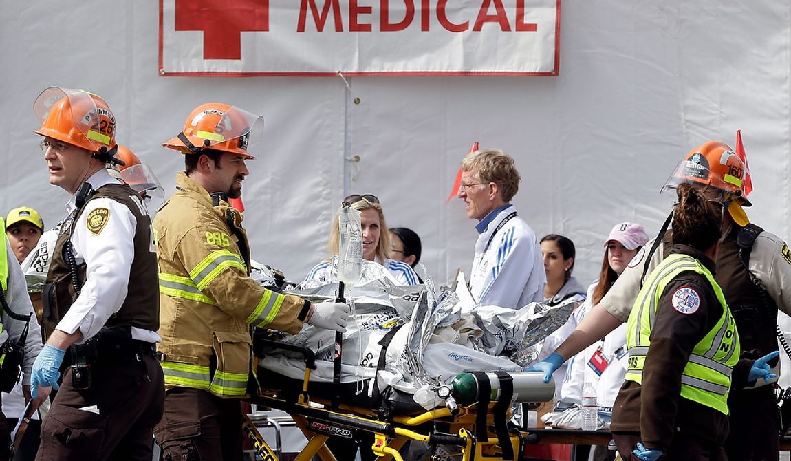 Medical personnel work outside the medical tent in the aftermath of two blasts which exploded near the finish line of the Boston Marathon in Boston, Monday, April 15, 2013. (AP Photo/Elise Amendola) 