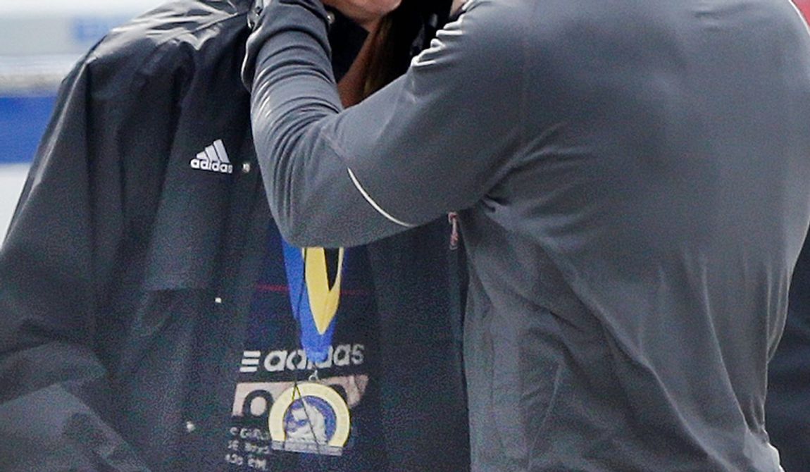 An unidentified Boston Marathon runner is comforted as she cries in the aftermath of two blasts which exploded near the finish line of the Boston Marathon in Boston, Monday, April 15, 2013. (AP Photo/Elise Amendola) 