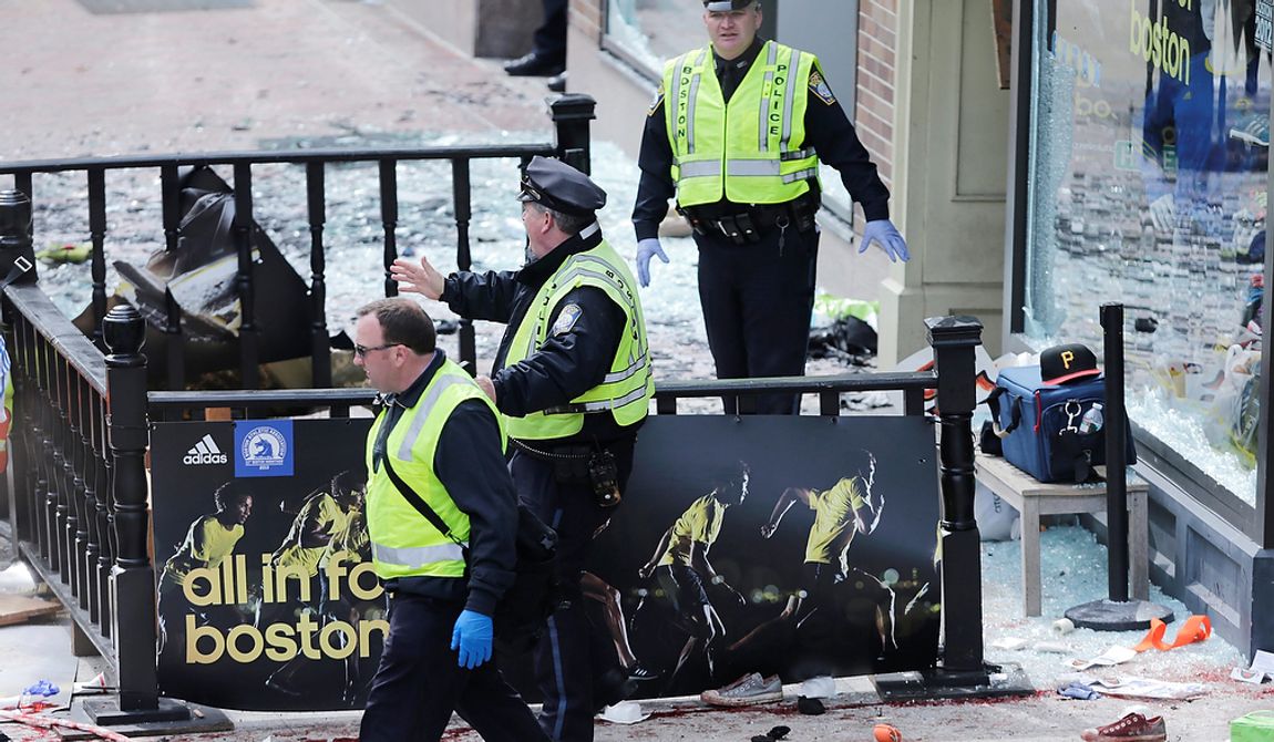 Boston police clear an area following an explosion near the finish line of the 2013 Boston Marathon in Boston, Monday, April 15, 2013. Two explosions shattered the euphoria of the Boston Marathon finish line on Monday, sending authorities out on the course to carry off the injured while the stragglers were rerouted away from the smoking site of the blasts. (AP Photo/Charles Krupa)