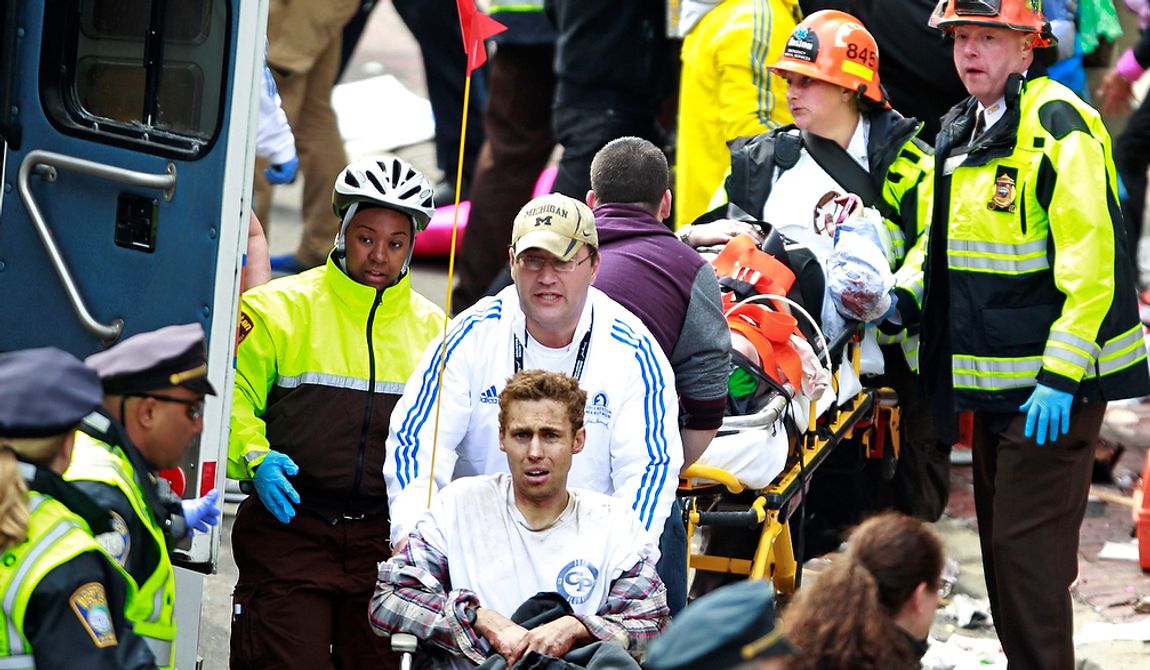 Medical workers aid injured people at the finish line of the 2013 Boston Marathon following an explosion in Boston, Monday, April 15, 2013. Two explosions near the finish of the Boston Marathon on Monday, killing at least  two people, injuring over 20 others. (AP Photo/Charles Krupa)
