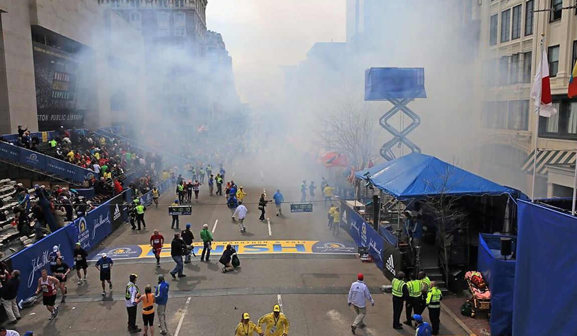 Medical workers aid injured people at the 2013 Boston Marathon following an explosion in Boston, Monday, April 15, 2013. Two explosions shattered the euphoria of the Boston Marathon finish line on Monday, sending authorities out on the course to carry off the injured while the stragglers were rerouted away from the smoking site of the blasts. (AP Photo/The Boston Globe, David L Ryan)  