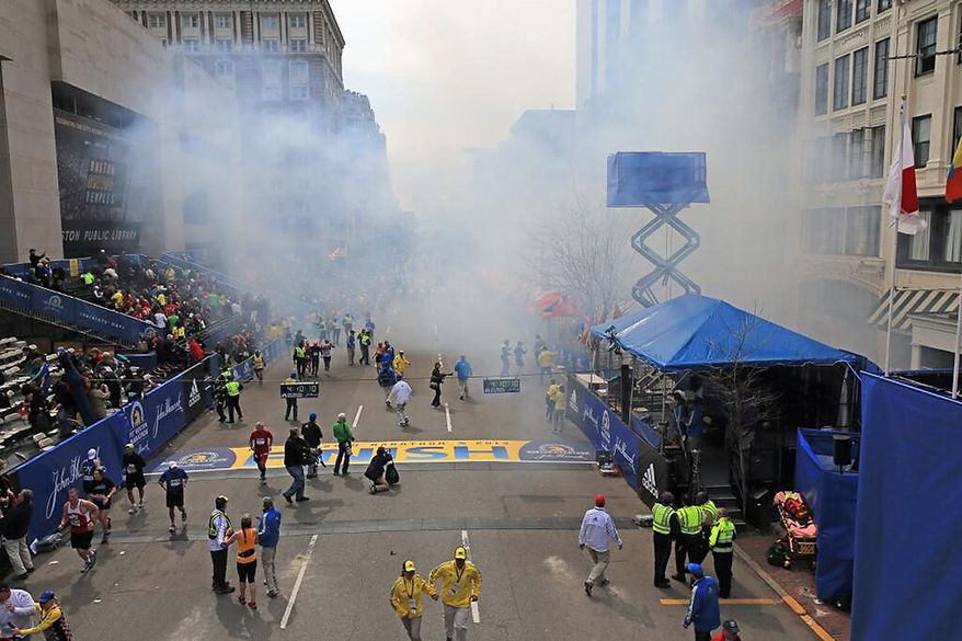 Medical workers aid injured people at the 2013 Boston Marathon following an explosion in Boston, Monday, April 15, 2013. Two explosions shattered the euphoria of the Boston Marathon finish line on Monday, sending authorities out on the course to carry off the injured while the stragglers were rerouted away from the smoking site of the blasts. (AP Photo/The Boston Globe, David L Ryan)