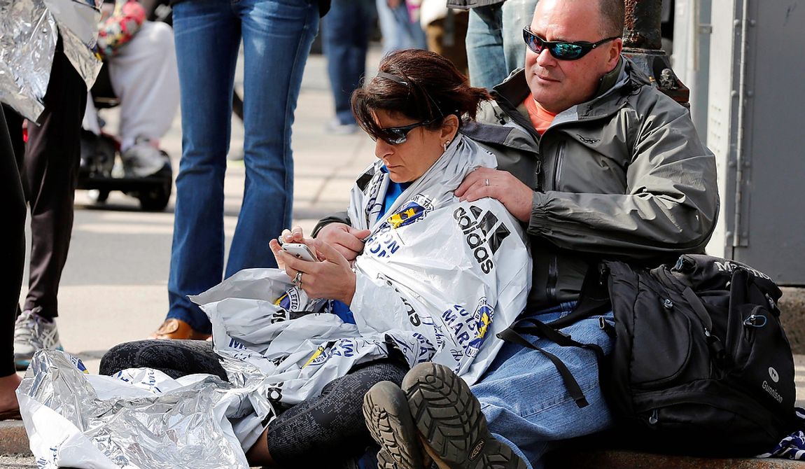 Chris Darmody, right, holds his wife Sue in Boston, Monday, April 15, 2013. Chris says he was waiting for Sue when an explosion detonated near his location at the finish line of the Boston Marathon. The couple were later reunited after all runners were diverted from the course. (AP Photo/Michael Dwyer)
