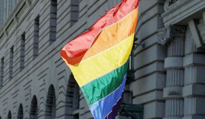 ** FILE ** In this June 5, 2012, file photo, gay marriage supporter Bob Sodervick holds a flag outside the 9th U.S. Circuit Court of Appeals in San Francisco. (Associated Press)