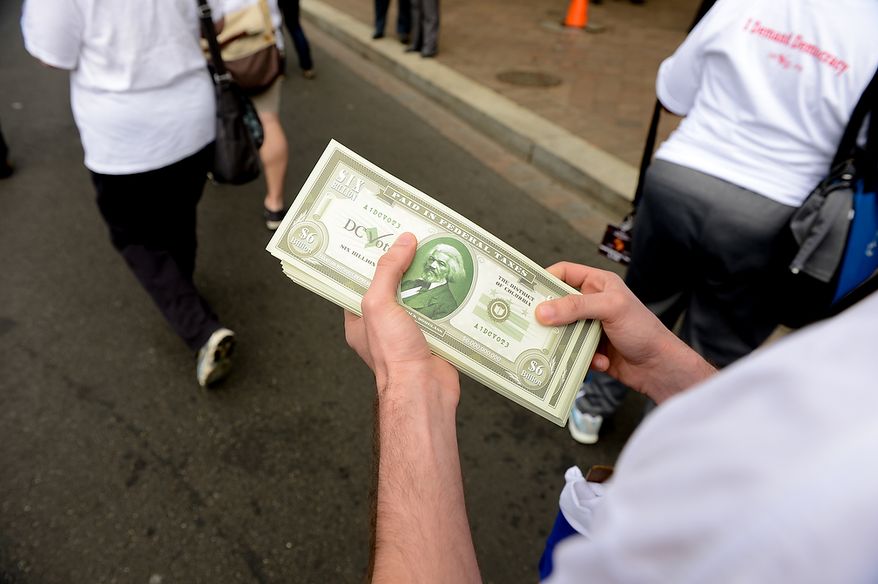 D.C. Vote activists hand out fake bills of 6,000,000,000 to show how much federal tax money residents paid without a voting representative in congress during the Washington, D.C. Emancipation Day parade, Washington, D.C., Tuesday, April 16, 2013. President Abraham Lincoln freed approximately 3,100 slaves in the District of Colombia on April 16, 1862, nine months before the Emancipation Proclamation. (Andrew Harnik/The Washington Times)