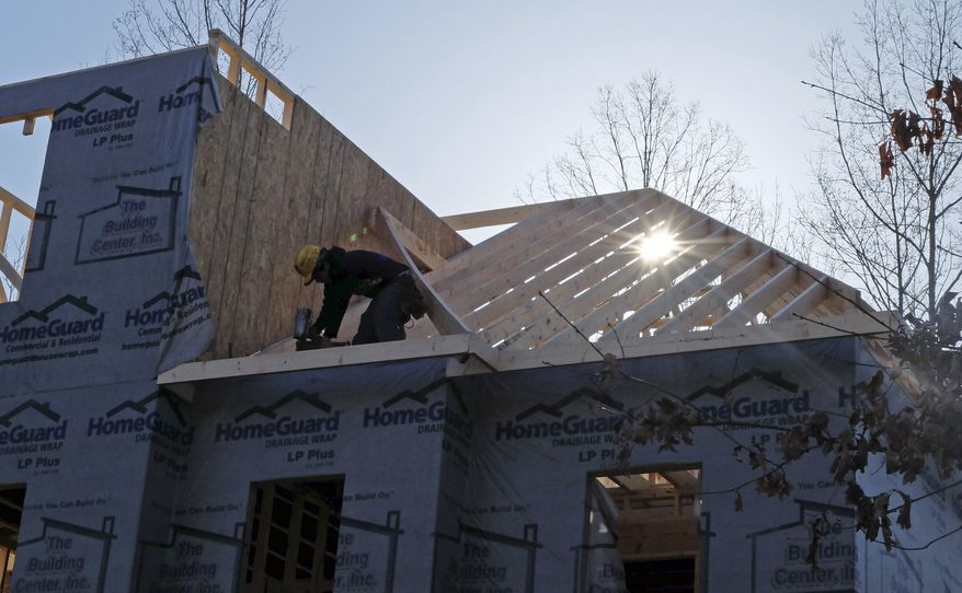 A worker helps frame a new home under construction in Matthews, N.C., on Friday, March 29, 2013. (AP Photo/Chuck Burton)