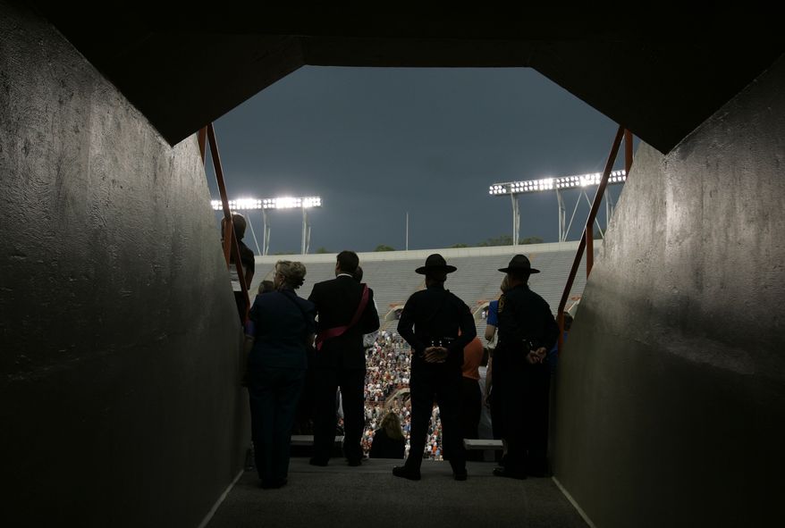 **FILE** Security personnel watch over the crowd during an undergraduate graduation ceremony at Virginia Tech in Lane Stadium in Blacksburg, Va., Friday, May 11, 2007. (AP Photo/Carolyn Kaster)
