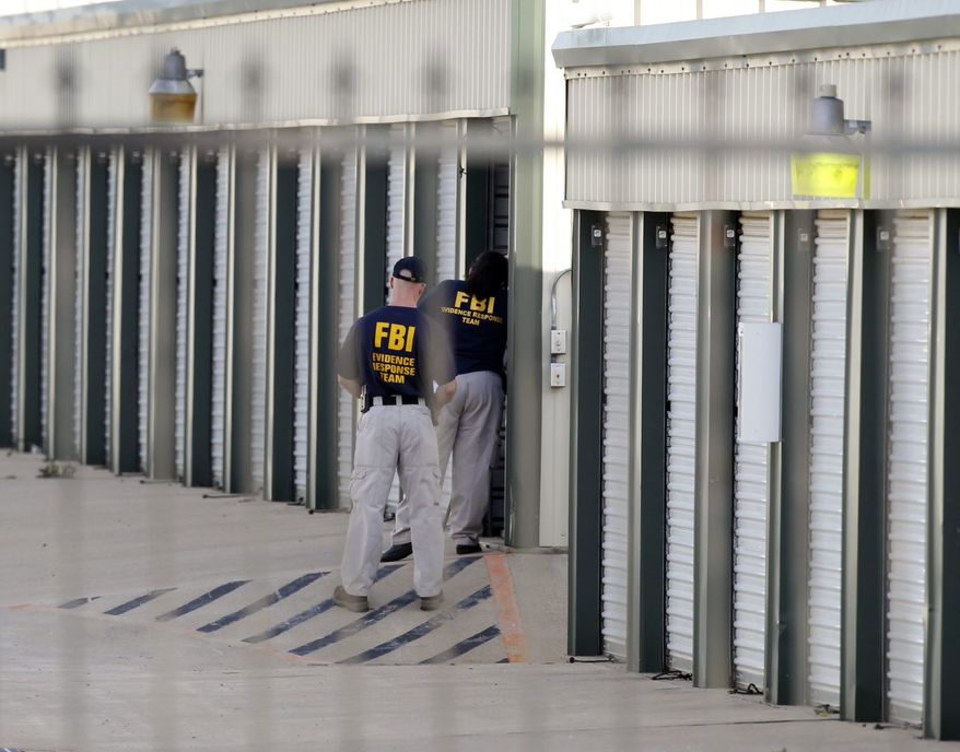 Authorities search a storage unit at Gibson Self Storage as they continue to investigate the slayings of Kaufman County District Attorney Mike McLelland, his wife and a top prosecutor, Saturday, April 13, 2013, in Seagoville, Texas. Authorities investigating the death of a Texas district attorney arrested Eric Williams, a former justice of the peace and charged him Saturday with making a "terroristic threat" after searching his home. (AP Photo/The Dallas Morning News, Michael Ainsworth)