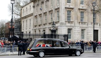 A hearse transporting the coffin containing the body of former British Prime Minister Margaret Thatcher makes its way past Downing Street in London, England, Wednesday, April 17, 2013. (AP Photo/Gareth Cattermole, Pool)

