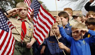 **FILE** From left, Joshua Kusterer, 12, Nach Mitschke, 6, and Wyatt Mitschke, 4, salute as they recite the pledge of allegiance during the “Save Our Scouts” prayer vigil and rally against allowing gays in the organization in front of the Boy Scouts of America National Headquarters in Dallas on Feb. 6, 2013. (Associated Press)