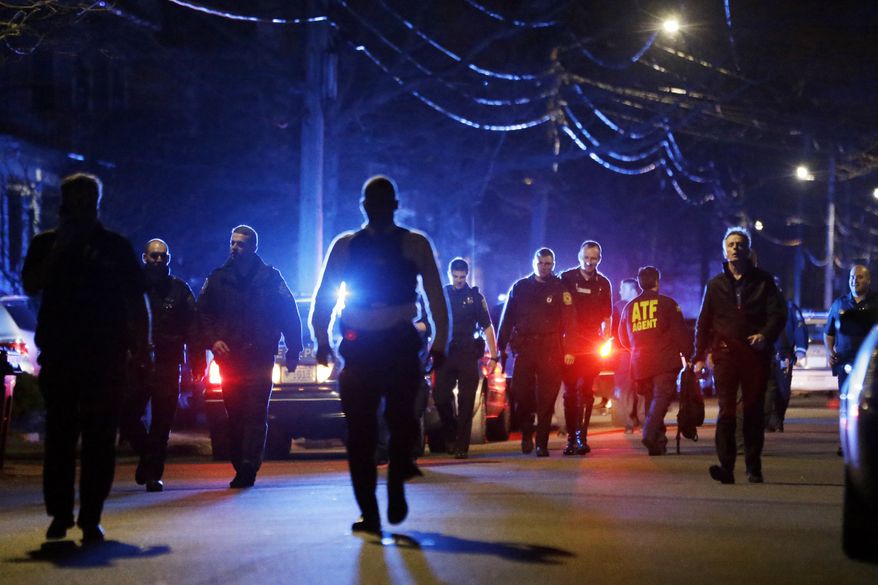 Police officers walk near a crime scene Friday, April 19, 2013, in Watertown, Mass. A tense night of police activity that left a university officer dead on campus just days after the Boston Marathon bombings and amid a hunt for two suspects caused officers to converge on a neighborhood outside Boston, where residents heard gunfire and explosions. (AP Photo/Matt Rourke)