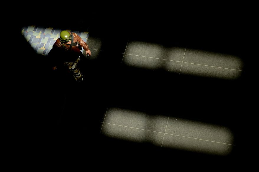 A man dressed as a military figure walks through a shaft of light at Awesome Con D.C., a comic book convention at the Washington Convention Center, Washington, D.C., Sunday, April 21, 2013. (Andrew Harnik/The Washington Times)