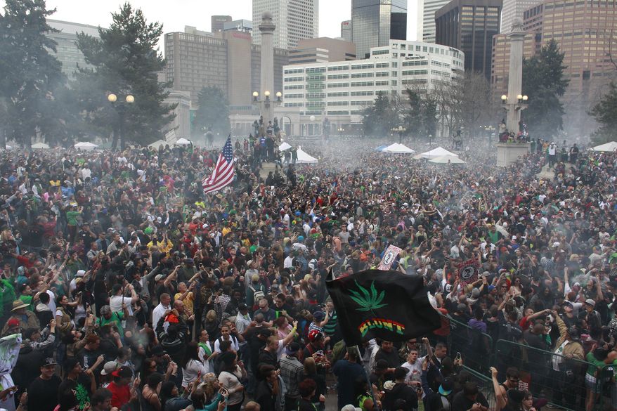 Attendees numbering in the tens of thousands smoke marijuana simultaneously at 4:20 p.m. at the Denver 420 pro-marijuana rally at Civic Center Park in Denver on Saturday, April 20, 2013. (AP Photo/Brennan Linsley)