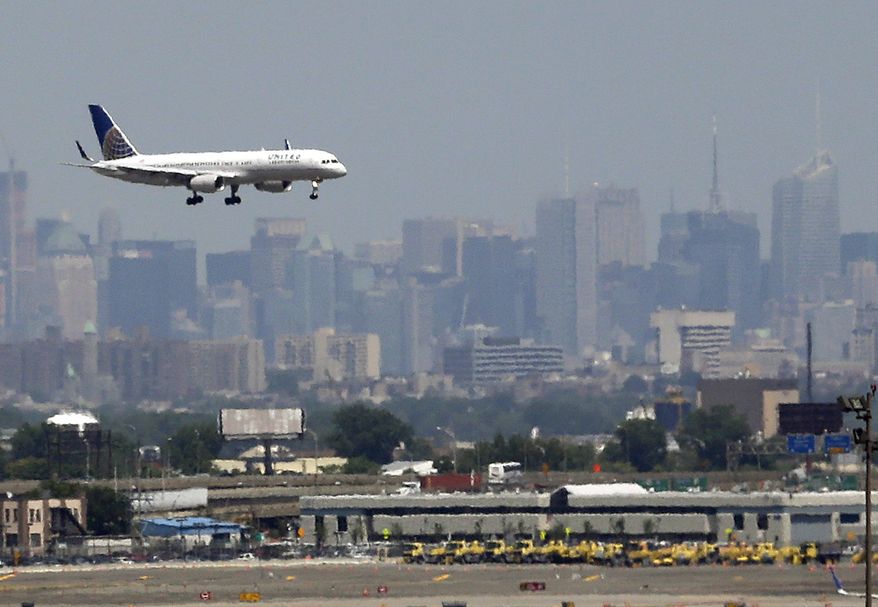 ** FILE ** A United Airlines jetliner prepares to land at Newark Liberty International Airport in Newark, N.J., on July 10, 2012. The New York City skyline is in the background. (AP Photo/Julio Cortez)