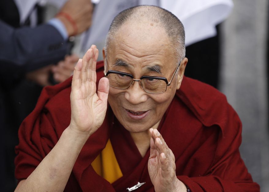 **FILE** Exiled Tibetan spiritual leader the Dalai Lama greets people after walking over the Londonderry Peace Bridge, during a visit to Londonderry, Northern Ireland, on April 18, 2013. The Dalai Lama walked across the city's iconic Peace Bridge with hundreds of children from across the religious divide. (Associated Press)