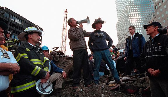 Standing on top of a crumpled fire truck with retired New York City firefighter Bob Beckwith, President George W. Bush rallies firefighters and rescue workers Friday, Sept. 14, 2001, during an impromptu speech at the site of the collapsed World Trade Center towers in New York City. &quot;I can hear you,&quot; President Bush said. &quot;The rest of the world hears you. And the people who knocked these buildings down will hear all of us soon.&quot;  Photographs by Eric Draper from Front Row Seat: A Photographic Portrait of the Presidency of George W. Bush(Copyright &amp;#194;&amp;#169; 2013). For more information visit www.utexaspress.com