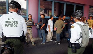** FILE ** This file photo taken July 28, 2010, shows a group of illegal immigrants waiting in line while being deported to Mexico at the Nogales Port of Entry in Nogales, Ariz. (AP Photo/Jae C. Hong, File)