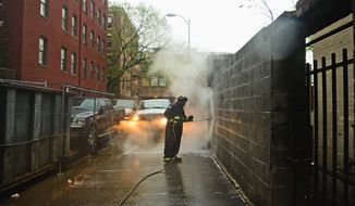Sanitation worker Sean Thomas uses hot water to remove graffiti from walls in the District on Thursday. Mr. Thomas has been cleaning graffiti for 10 years.(Andrew Harnik/The Washington Times)