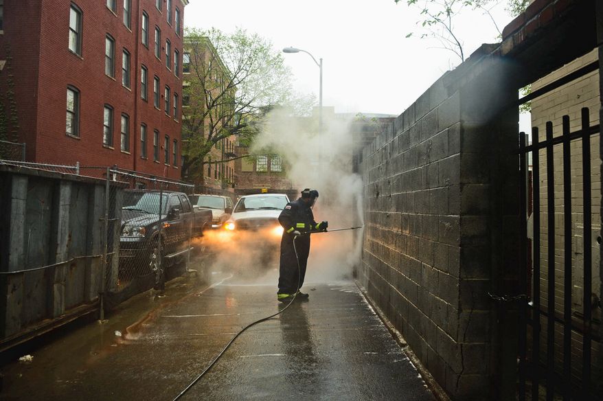 Sanitation worker Sean Thomas uses hot water to remove graffiti from walls in the District on Thursday. Mr. Thomas has been cleaning graffiti for 10 years.(Andrew Harnik/The Washington Times)
