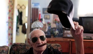 In this April 23, 2013 photo, Conrado Marrero, the world&#39;s oldest living former major league baseball player, poses for a photo as he holds his baseball cap and an unlit cigar in his mouth two days before is 102nd birthday at his home in Havana, Cuba. In addition to his longevity, the former Washington Senator has much to celebrate this year. After a long wait, he finally received a $20,000 payout from Major League baseball granted to old-timers who played between 1947 and 1979. The money had been held up since 2011 due to issues surrounding the 51-year-old U.S. embargo on Cuba, which prohibits most bank transfers to the Communist-run island. But the payout finally arrived in two parts, one at the end of last year, and the second a few months ago, according to Marrero&#39;s family. (AP Photo/Franklin Reyes)