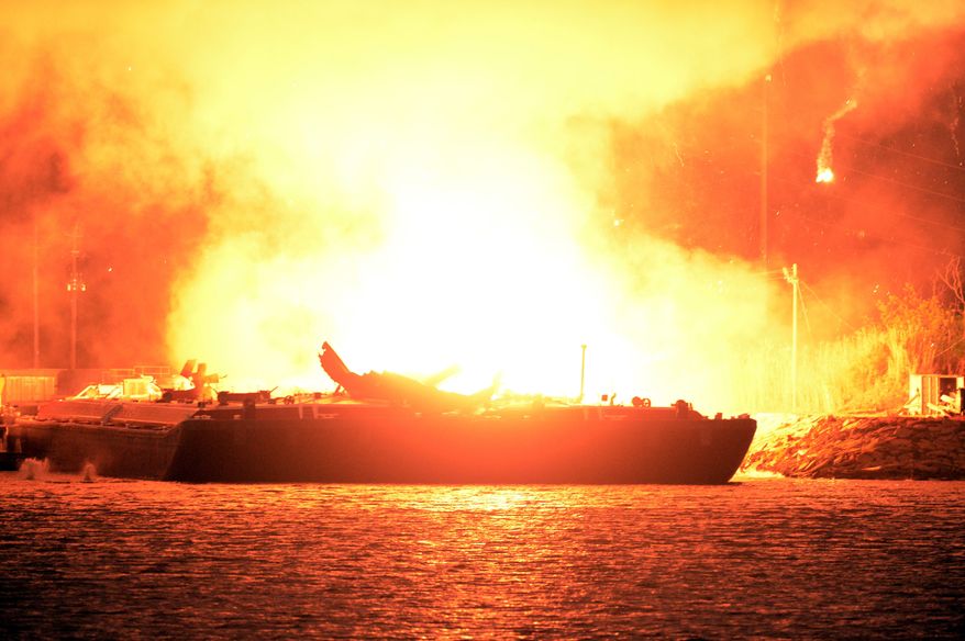 A massive explosion at 3 a.m. EDT on one of the two barges still ablaze in the Mobile River in Mobile, Ala., on Thursday, April 25, 2013. Three people were injured in the blast. (AP Photo John David Mercer)
