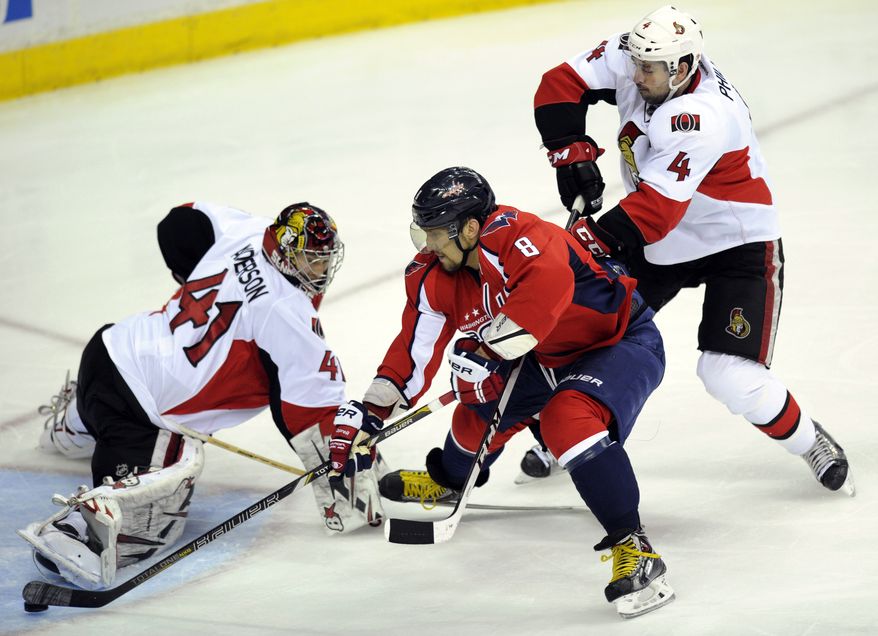 Washington Capitals left wing Alex Ovechkin (8), of Russia, skates past Ottawa Senators goalie Craig Anderson (41) and Chris Phillips (4) en route to scoring a goal during the third period of an NHL hockey game, Thursday, April 25, 2013, in Washington. Ottawa won 2-1 in overtime. (AP Photo/Nick Wass)