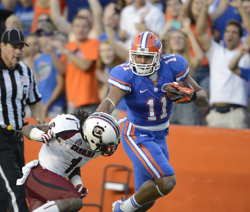 Florida's Jordan Reed (11) stiff-arms South Carolina's Ace Sanders on a punt return during the second half of an NCAA college football game Saturday, Oct. 20, 2012, in Gainesville, Fla. Florida won 44-11. (AP Photo/Phil Sandlin)