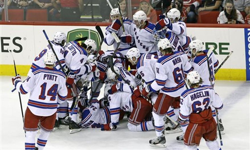 The New York Rangers celebrate Ryan Callahan's overtime goal to defeat the Carolina Hurricanes in an NHL hockey game in Raleigh, N.C., Thursday, April 25, 2013. New York won 4-3. (AP Photo/Gerry Broome)