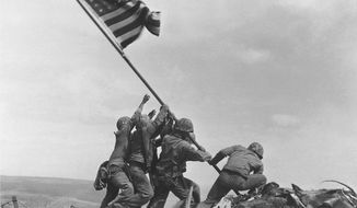 U.S. Marines of the 28th Regiment, 5th Division, raise the American flag atop Mount Suribachi on Iwo Jima on Feb. 23, 1945, in a Pulitzer Prize-winning photo by Associated Press photographer Joe Rosenthal. (AP Photo/Joe Rosenthal)