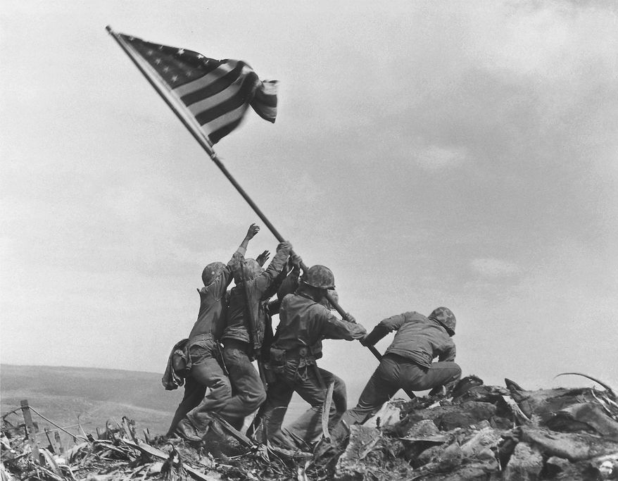 U.S. Marines of the 28th Regiment, 5th Division, raise the American flag atop Mount Suribachi on Iwo Jima on Feb. 23, 1945, in a Pulitzer Prize-winning photo by Associated Press photographer Joe Rosenthal. (AP Photo/Joe Rosenthal)
