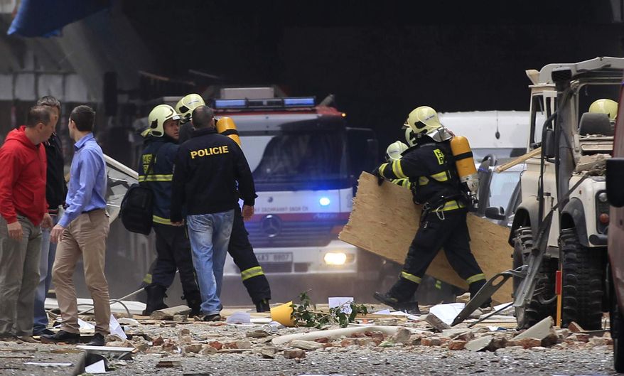 Policemen and firefighters inspect the scene of an explosion in downtown Prague, Czech Republic, Monday, April 29, 2013. Police said a powerful explosion has damaged a building in the center of the Czech capital, and they believe some people are buried in the rubble. (AP Photo/Petr David Josek)