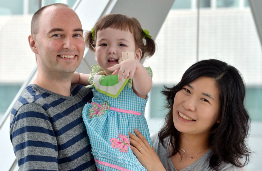 **FILE** Hannah Warren, 2, poses with her parents Lee Young-mi and Darryl Warren at Seoul National University Hospital in Seoul on July 13, 2012. Hannah, who was born without a windpipe, received a new windpipe made from her own stem cells in a landmark operation on April 9, 2013, at Children's Hospital of Illinois in Peoria, Ill. She is the youngest patient ever to get the experimental treatment. (Associated Press/The Korea Herald)