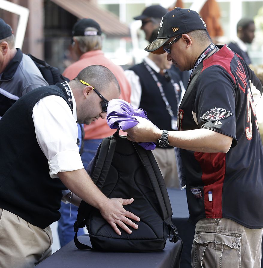**FILE** In this photo taken Wednesday, April 24, 2013, a security guard checks the backpack of a fan entering AT&T Park before a baseball game between the San Francisco Giants and the Arizona Diamondbacks in San Francisco. Major League Baseball's previously scheduled security meeting in New York took on added importance in the aftermath of the marathon bombs. Each team sets its own security standards, although clubs might consider cutting the size of the general major league limitation on bags from 16x16x8 inches to something less.(AP Photo/Jeff Chiu)