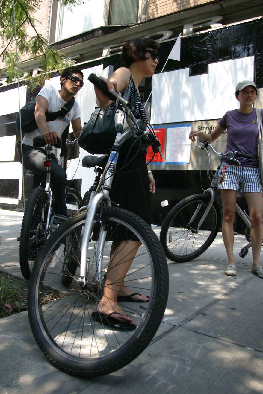 **FILE** James Vicente (left), Audrey Hawkins (center) and Julia Li borrow bicycles at the New York Bike-Share Project in the Storefront for Art and Architecture in New York on July 8, 2007. (Associated Press)
