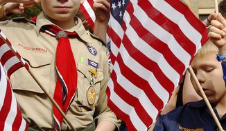 **FILE** From left, Joshua Kusterer, 12, Nach Mitschke, 6, and Wyatt Mitschke, 4, salute as they recite the pledge of allegiance during the “Save Our Scouts” prayer vigil and rally against allowing gays in the organization in front of the Boy Scouts of America National Headquarters in Dallas on Feb. 6, 2013. (Associated Press)