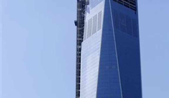 The final piece of the spire is hoisted to the roof of One World Trade Center, Thursday, May 2, 2013 in New York. The piece will be attached to the spire at a later date, capping off the tower at 1,776 feet. (AP Photo/Mark Lennihan)