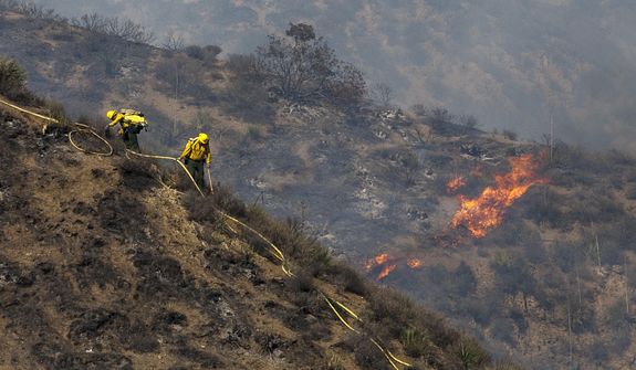 Firefighters work at a burned area on a hillside during a wildfire in Camarillo, Calif., Thursday, May 2, 2013. (AP Photo/Ringo H.W. Chiu)