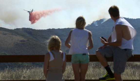 Residents watch an air tanker drop fire retardant during a wildfire that burned several thousand acres, Thursday, May 2, 2013, in Ventura County, Calif.   (AP Photo/Mark J. Terrill)