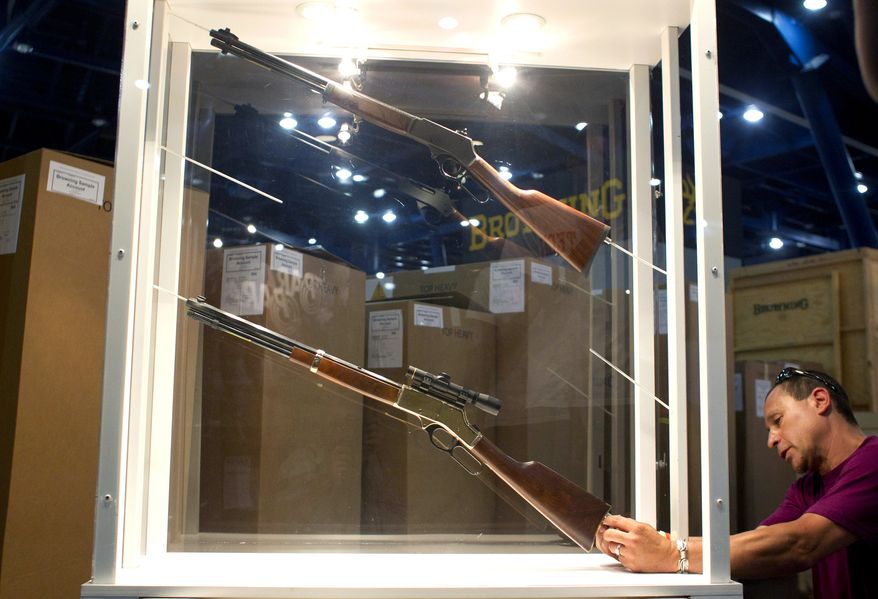 Johnny Bass sets up the Henry Repeating Arms Company booth as exhibitors prepares for National Rifle Association Meetings and Exhibits at the George R. Brown Convention Center on Wednesday, May 1, 2013, in Houston. The 2013 NRA Annual Meetings and Exhibits is scheduled to being Friday. (AP Photo/Houston Chronicle, Johnny Hanson)