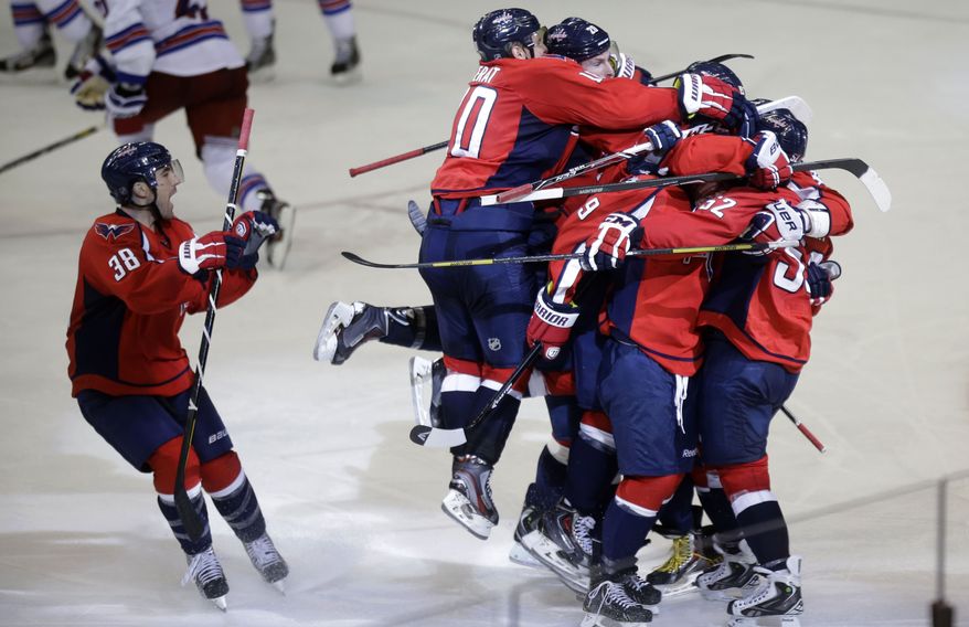 Washington Capitals defenseman Mike Green, right, is congratulated by teammates after he scored the game winning goal in overtime of Game 2 of a Stanley Cup NHL playoff hockey series against the New York Rangers on Saturday, May 4, 2013, in Washington. The Capitals defeated the Rangers 1-0 in overtime. (AP Photo/Evan Vucci)